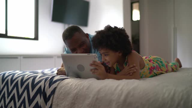 祖父和孙女在家里用平板电脑看东西视频素材