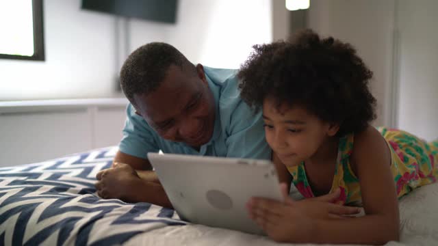 祖父和孙女在家里用平板电脑看东西视频素材
