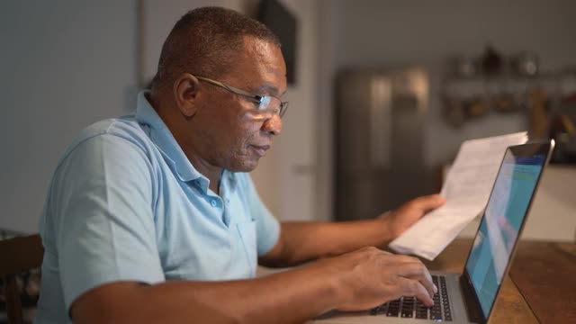 老年人用笔记本电脑支付账单或处理家庭财务视频下载