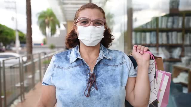在冠状病毒大流行结束时，一名高层妇女微笑着摘下口罩视频下载