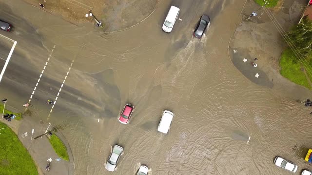 交通车辆在被雨水淹没的道路上行驶的鸟瞰图。视频素材