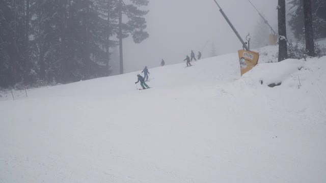人们在低能见度和浓雾的斜坡上滑雪视频素材