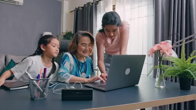 奶奶坐在电脑上学习如何使用互联网，教孙子视频下载
