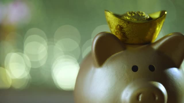 金色的小猪储蓄罐，装饰装饰用金锭作皇冠视频素材