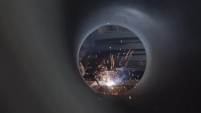 一名焊工正在焊接金属摄像机的角度，通过一根大管子，工业视频素材