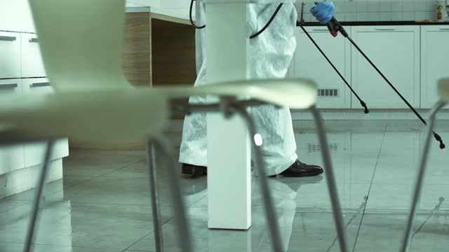卫生工人穿着防护服对厨房区域进行消毒视频素材