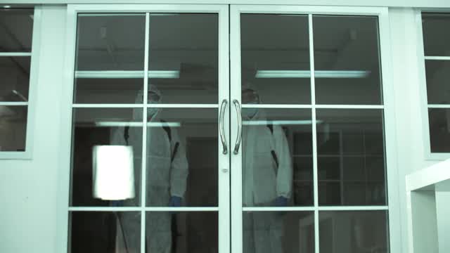 公用事业工人使用手动消毒机为办公室消毒视频素材