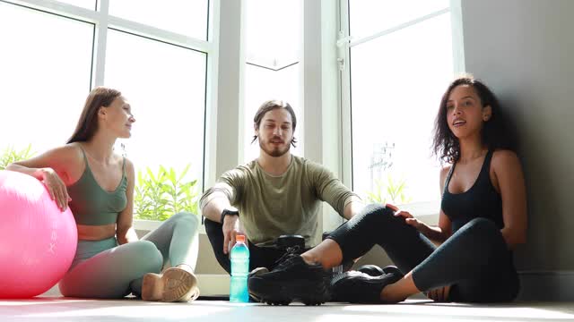 一群多样化的运动人士在健身房锻炼后一起愉快地交谈和大笑。健康的生活方式和运动概念。视频下载