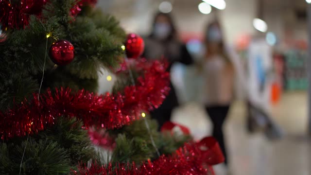 圣诞树矗立的购物中心模糊了行人的背景视频素材