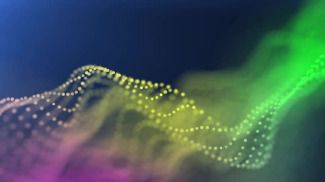 多种颜色的粒子在一个波浪形的特写中移动，边缘模糊。用作设计和展示的背景视频下载