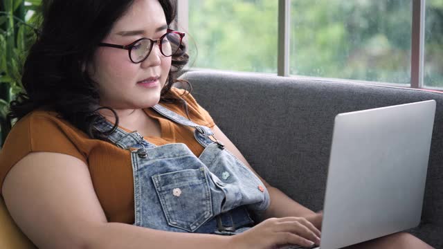 身材魁梧的女人在家里用笔记本电脑工作视频素材