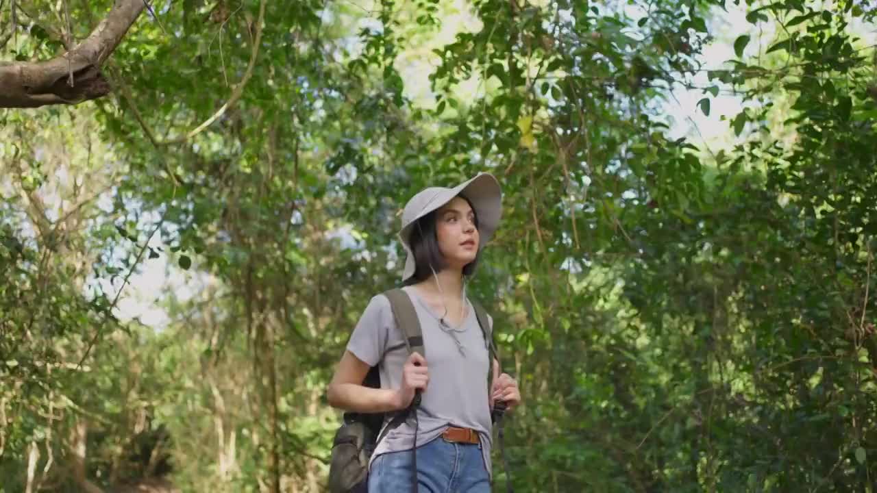 一个年轻的白人女人一起在森林里旅行。女孩在大自然中感受着清新、美妙、刺激和放松，环顾四周的风景，然后继续快乐地散步。视频下载