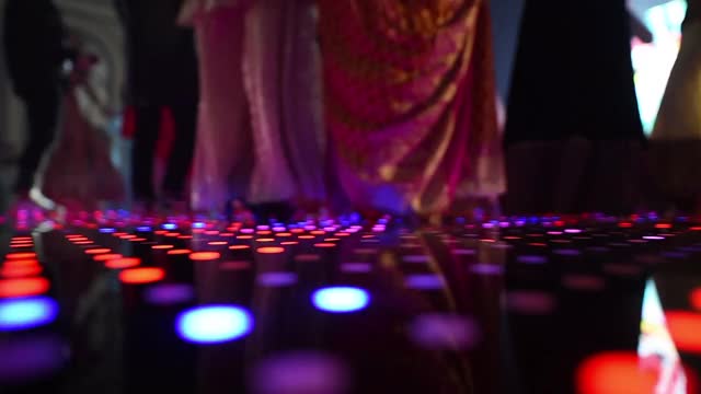 大厅内一群人在LED照明的舞池中跳舞视频素材