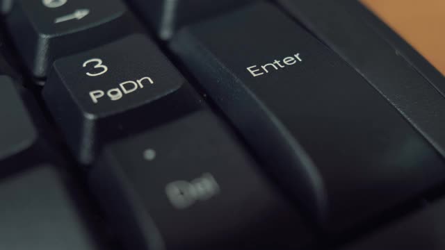 人类的手指在黑色键盘上反复按下输入键。视频素材