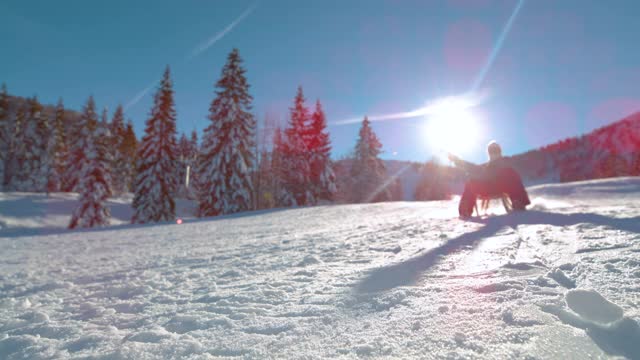 镜头光晕:快乐的女人滑下斯洛文尼亚阳光明媚的雪山。视频素材
