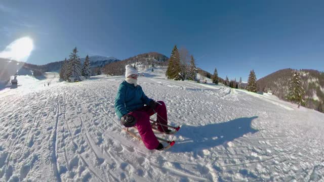 自拍:阳光明媚的冬日里，活跃的年轻白种女子从雪山上滑下来视频素材