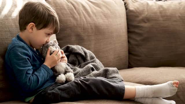 严肃沉思的小男孩抚摸着他的毛绒玩具猫视频下载