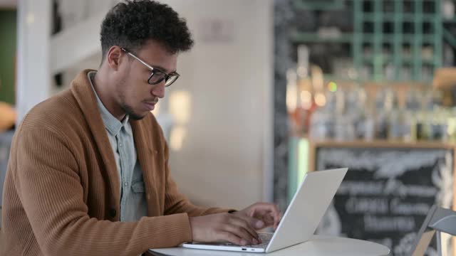 非洲人在咖啡馆使用笔记本电脑时头痛视频素材