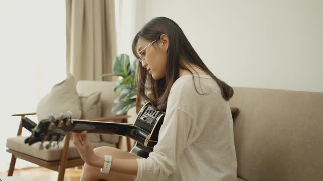 亚洲女孩弹吉他直播视频素材