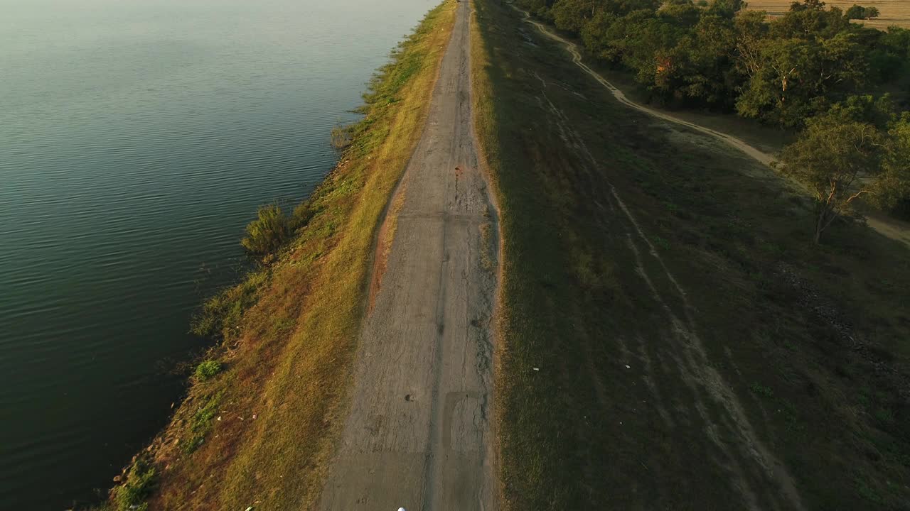 无人机拍摄到一个人在湖边跑步视频素材