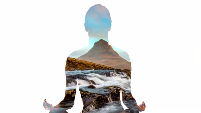 女子在Kirkjufell山和Kirkjufellsfoss瀑布边冥想视频素材