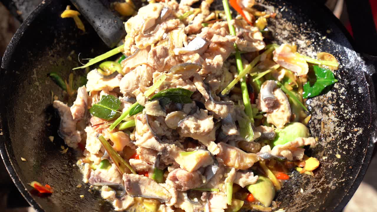 在餐馆里用平底锅煸炒香辣鱼肉，把切成薄片的鱼和蔬菜香草混合在一起视频素材