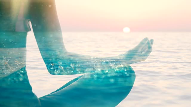 一个女人的剪影在荷花的位置浮动在海上在日落视频素材