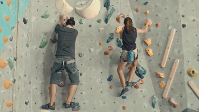 父亲和女儿在攀岩馆成功攀爬后击掌，慢动作视频下载