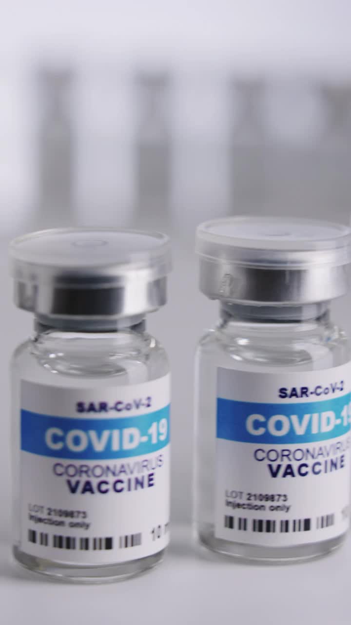 白色背景的垂直Covid-19疫苗瓶视频素材