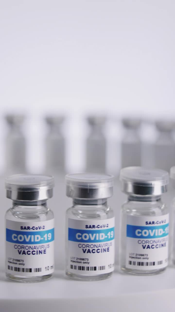 白色背景的垂直Covid-19疫苗瓶视频素材