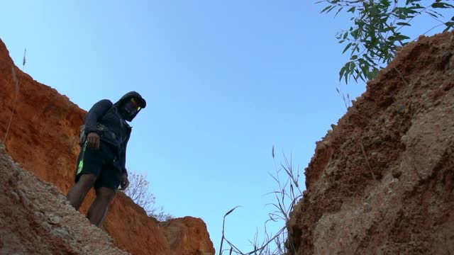 徒步旅行者从岩石上跳下来视频素材