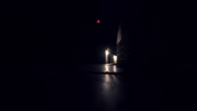 女孩在夜晚走在空旷黑暗的巷子里视频素材