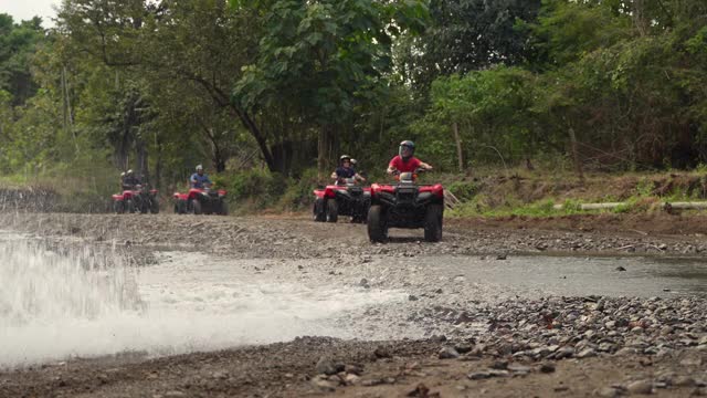 一群游客驾驶4x4自行车通过水在哥斯达黎加视频素材