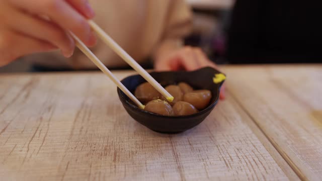 一名年轻女子在居酒屋吃日本美食“魔芋”视频下载