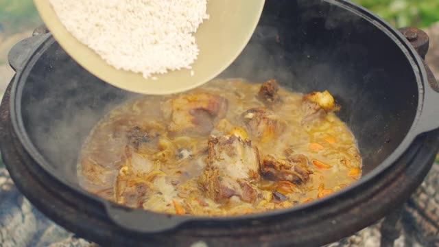 用肉，胡萝卜，大蒜和香料烹制传统的乌兹别克肉饭。在一个大平底锅里又漂亮又好吃。视频下载