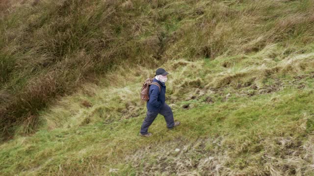 高角度的一个活跃的老年人在苏格兰西南部偏远的乡村位置散步视频下载