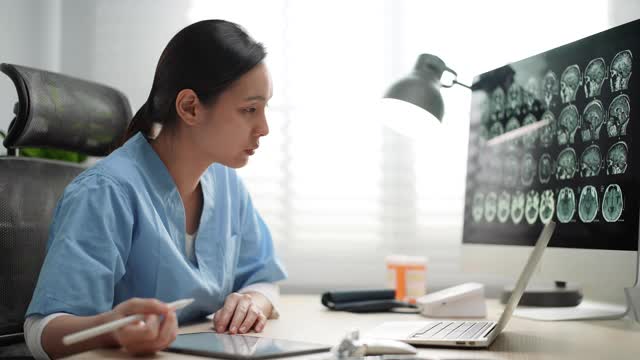 年轻的亚洲医生在医院使用笔记本电脑视频素材