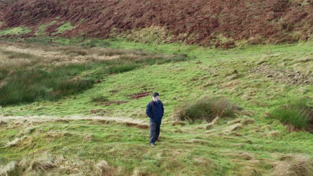 高角度的一个活跃的资深男子环顾四周，然后离开在苏格兰西南部偏远的农村位置视频下载