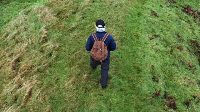 一个活跃的老年人在苏格兰西南部偏远的农村地区徒步旅行的高角度视图视频下载