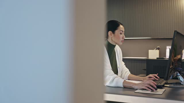 侧视图视频中年亚洲专业人员在她的办公桌工作视频下载