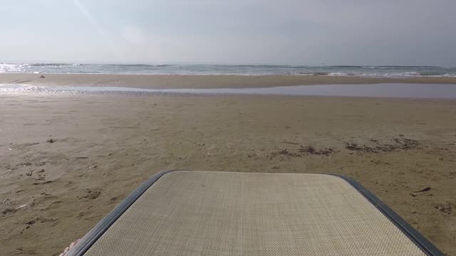 沙滩上有一张躺椅，一个人把脚搁在上面视频下载