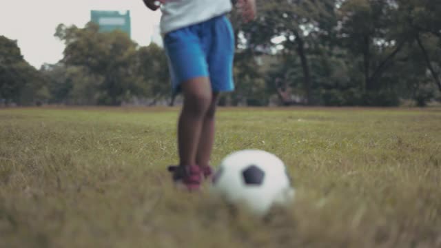男孩在公园里踢足球视频素材