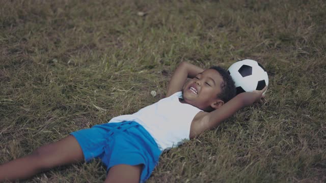 男孩在公园里踢足球视频素材