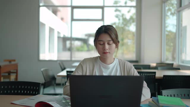 亚洲学生妇女阅读和研究研究的书房在图书馆视频素材