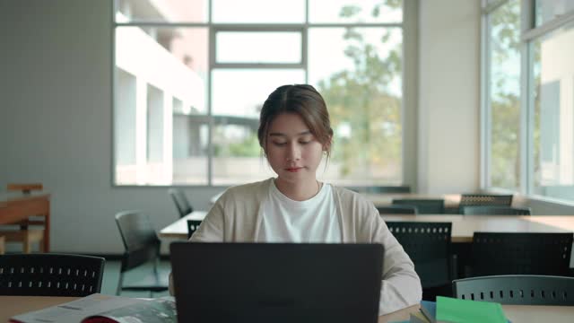 亚洲学生妇女阅读和研究研究的书房在图书馆视频素材