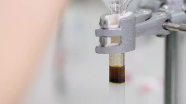 研究人员将棕色样品装入玻璃柱中，用sed溶剂将样品洗脱出柱外。硅胶被包装成一个柱。柱层析技术。电子学习的概念。视频素材