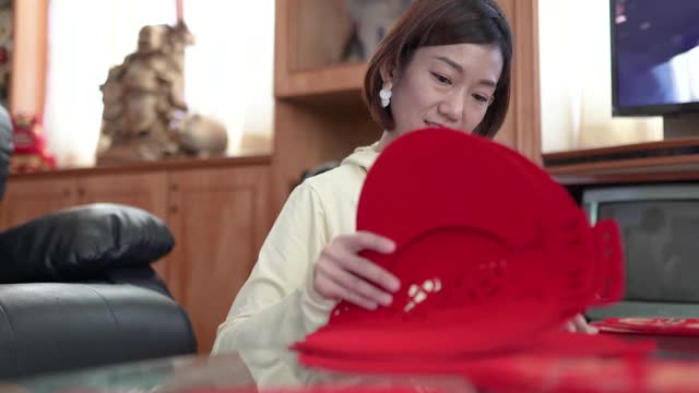 亚洲华人妇女为家里准备春节装饰品。在家庆祝中国新年。传统的新年庆祝。视频素材