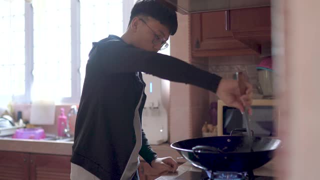 亚洲华人少年在厨房做饭，准备年夜饭视频下载