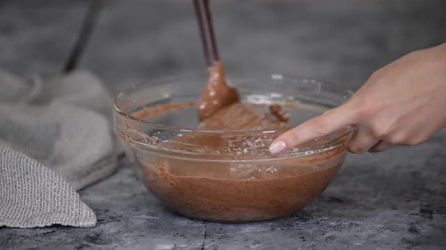 女性的手在为蛋糕搅拌巧克力面糊视频素材