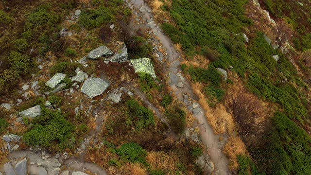 无人机拍摄的两名跑步者沿着山上的一条石头小路跑步视频下载